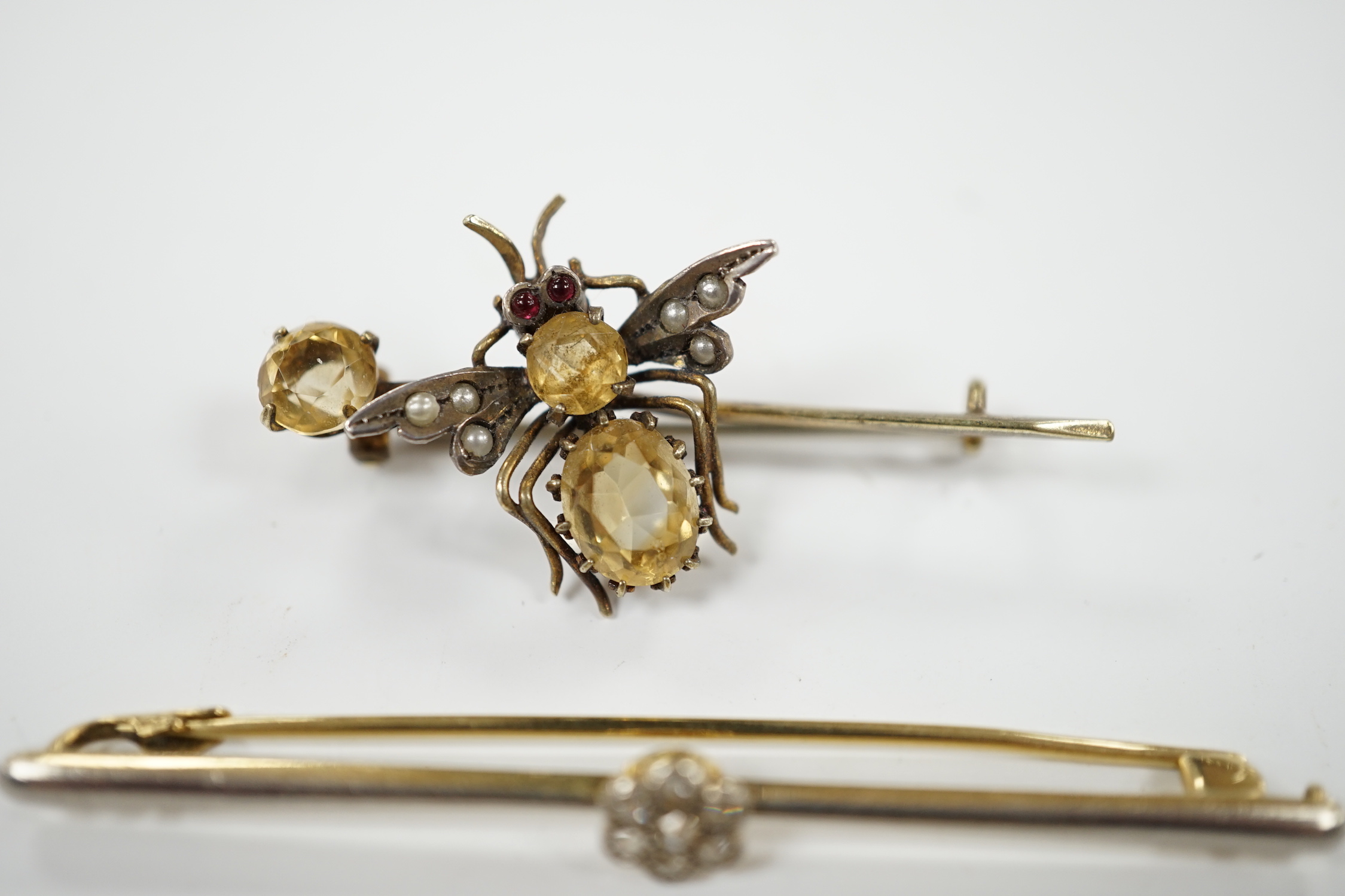 An Edwardian 15ct and diamond cluster set bar brooch, 60mm and two other gem set bar brooches including a bug brooch.